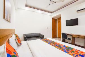 a bedroom with a bed and a desk and a television at FabHotel Emoji Stays in Gurgaon +21 photos