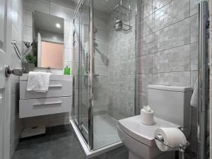 a white bathroom with a shower and a toilet at Stunning West End 3 Bed in Glasgow