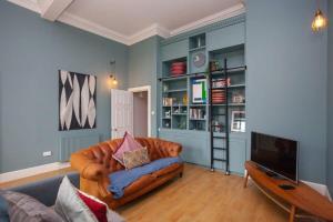 a living room with a couch and a television at Bright Spacious 3 Bed Flat in Glasgow