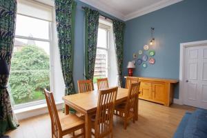 uma sala de jantar com uma mesa de madeira e cadeiras em Bright Spacious 3 Bed Flat em Glasgow