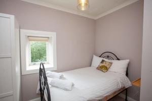 Bright Spacious 3 Bed Flat في غلاسكو: غرفة نوم صغيرة بها سرير ونافذة
