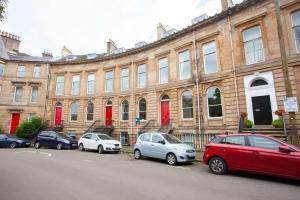 a group of cars parked in front of a building at Bright Spacious 3 Bed Flat in Glasgow