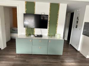 a living room with a blue cabinet with a flat screen tv at Smart Home - Die etwas andere Ferienwohnung! in Brandenburg an der Havel