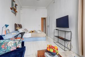 a living room with a blue couch and a tv at 372 Suite Saulnier 2 - Superbe Appartement à Paris in Paris