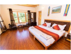 1 dormitorio con 1 cama grande en una habitación en Kartok resort, Leh, en She
