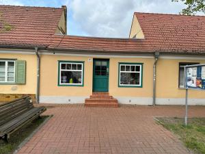 uma casa com uma porta verde e um banco em Smart Home - Die etwas andere Ferienwohnung! em Brandenburg an der Havel