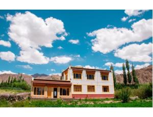 una casa en medio de un campo con un cielo en Kartok resort, Leh, en She
