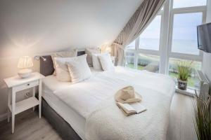 a bedroom with a white bed with a hat on it at Ocean 3 in Rettin