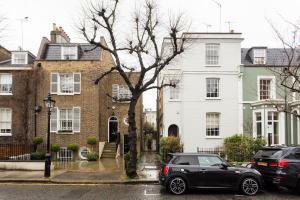 un coche negro estacionado frente a una casa en Artistic 1bed flat with patio in South Kensington, en Londres