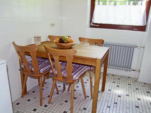 a wooden table with two chairs and a bowl of fruit on it at Haus Elisabeth - Fewo Glottertal, 1 Schlafzimmer, Feldberg nahe Skipiste in Neuglashütten
