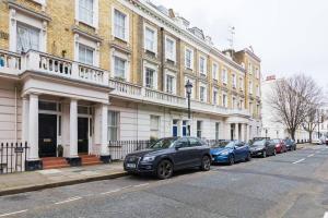 een rij auto's geparkeerd voor een gebouw bij Special offer! Fantastic 1 bed flat in Pimlico in Londen