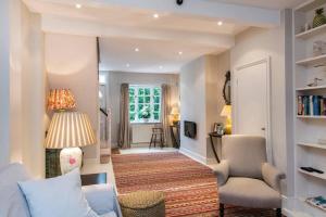 uma sala de estar com um sofá e uma cadeira em Delightful 2 Bed House in Stylish Fulham em Londres