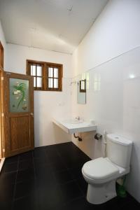 un baño con inodoro y lavabo en Serene Home Stay, en Udawalawe 32 fotos más