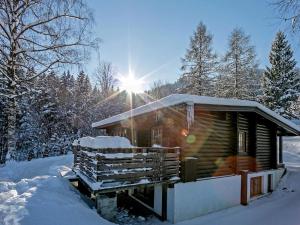 une cabane en rondins dans la neige avec le soleil derrière elle dans l'établissement Spacious Chalet in W rgl Boden near Ski Area, à Wörgl