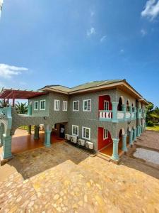 ein großes Gebäude mit einer roten Tür in der Unterkunft THE GREEN CONDO in Elmina