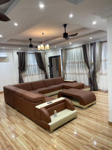 ein großes Wohnzimmer mit einem Sofa und einem Tisch in der Unterkunft THE GREEN CONDO in Elmina
