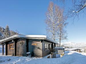 eine Holzhütte im Schnee mit Schnee auf dem Dach in der Unterkunft Spacious Chalet in W rgl Boden near Ski Area in Wörgl