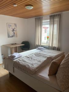a bedroom with a large bed with a wooden ceiling at Pension zur Sonnenalb in Sonnenbühl