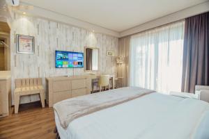 a hotel room with a bed and a television at Dreamland Oasis Aparthotel in K'obulet'i