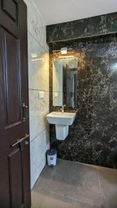 a bathroom with a sink and a mirror at Janardhana Residency in Dharmastala