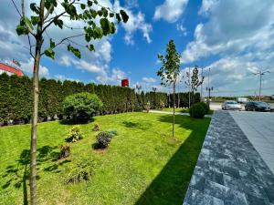 Vera HOTEL-VILLA في بريشتيني: حديقة فيها اشجار وعشب وممشى