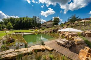 a swimming pool with a patio and an umbrella at Wellness & spa hotel Augustiniánský dům in Luhačovice