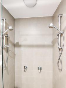 eine Dusche mit Glastür im Bad in der Unterkunft Hamptons Style 2BR & kid room w view in Olympic Park in Sydney