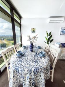 a dining room with a table with a blue and white table cloth at Hamptons Style 2BR & kid room w view in Olympic Park in Sydney