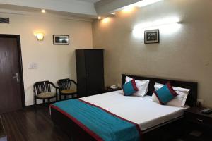 a bedroom with a bed and two chairs in it at OYO Vatika in Gurgaon