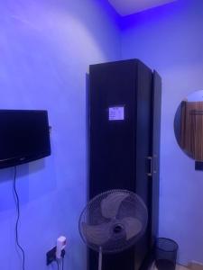una nevera negra en una habitación con ventilador en BLUE AO HOTEL, en Lagos