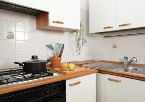 a kitchen with a stove with a pot on it at HoliHome - Nobil Villani - Bilocale piano terra in Tortoreto Lido +12 photos