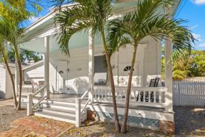 een wit huis met palmbomen ervoor bij Mesa House, Dos by Brightwild-Unreal Location in Key West