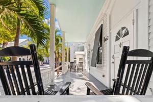 two chairs sitting on the porch of a house at Mesa House, Dos by Brightwild-Unreal Location in Key West