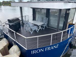 a blue boat with a table and chairs on the deck at Hausboot Iron Franz- Entspannung auf dem Wasser in Düsseldorf
