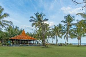 a gazebo with an orange roof and palm trees at LA CASA BORNEO in Bentakan Kecil