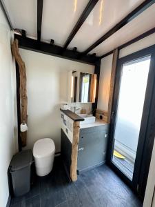 La salle de bains est pourvue de toilettes, d'un lavabo et d'une fenêtre. dans l'établissement Hausboot Iron Franz- Entspannung auf dem Wasser, à Düsseldorf