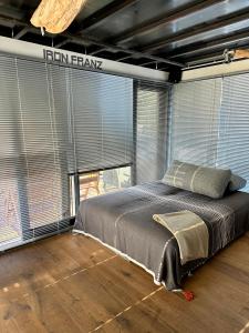 een slaapkamer met een bed in een kamer met grote ramen bij Hausboot Iron Franz- Entspannung auf dem Wasser in Düsseldorf