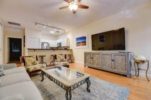 a living room with a couch and a tv at The Mesa House-Close to Duval! in Key West