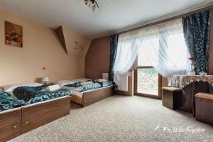 um quarto com 2 camas e uma grande janela em Willa Krystian em Murzasichle