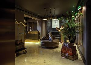 a living room with a couch and a potted plant at Hotel Gotham in Manchester