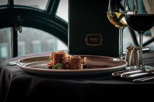a plate of food on a table with a glass of wine at Hotel Gotham in Manchester