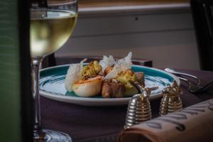 a plate of food on a table with a glass of wine at Hotel Gotham in Manchester