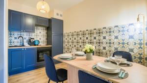 een keuken met een houten tafel en blauwe kasten bij Apartamenty Sun & Snow Villa Verona in Mielno