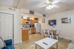 a living room with a table and a kitchen with a ceiling fan at Sea Breeze -Great Location! in Key West +13 photos