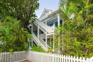a white fence in front of a house at Sky Loft in Key West by Brightwild in Key West