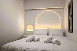 a white bed with two pillows on top of it at Bluewave Lux house in Ornos