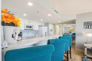 a kitchen with blue chairs and a bar with a counter at The Salt Cay by Brightwild-Modern & Pet Friendly in Key West