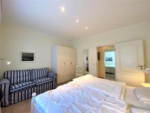 une chambre avec un lit et un canapé dans l'établissement Haus Villa am Meer, An der Rennweide 20, à Dangast