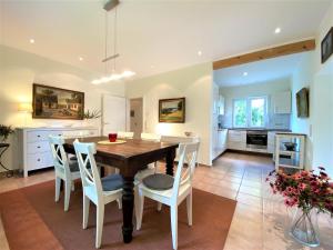 une cuisine et une salle à manger avec une table et des chaises en bois dans l'établissement Haus Villa am Meer, An der Rennweide 20, à Dangast
