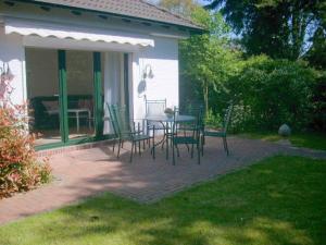 un patio avec une table et des chaises dans une cour dans l'établissement Haus Villa am Meer, An der Rennweide 20, à Dangast